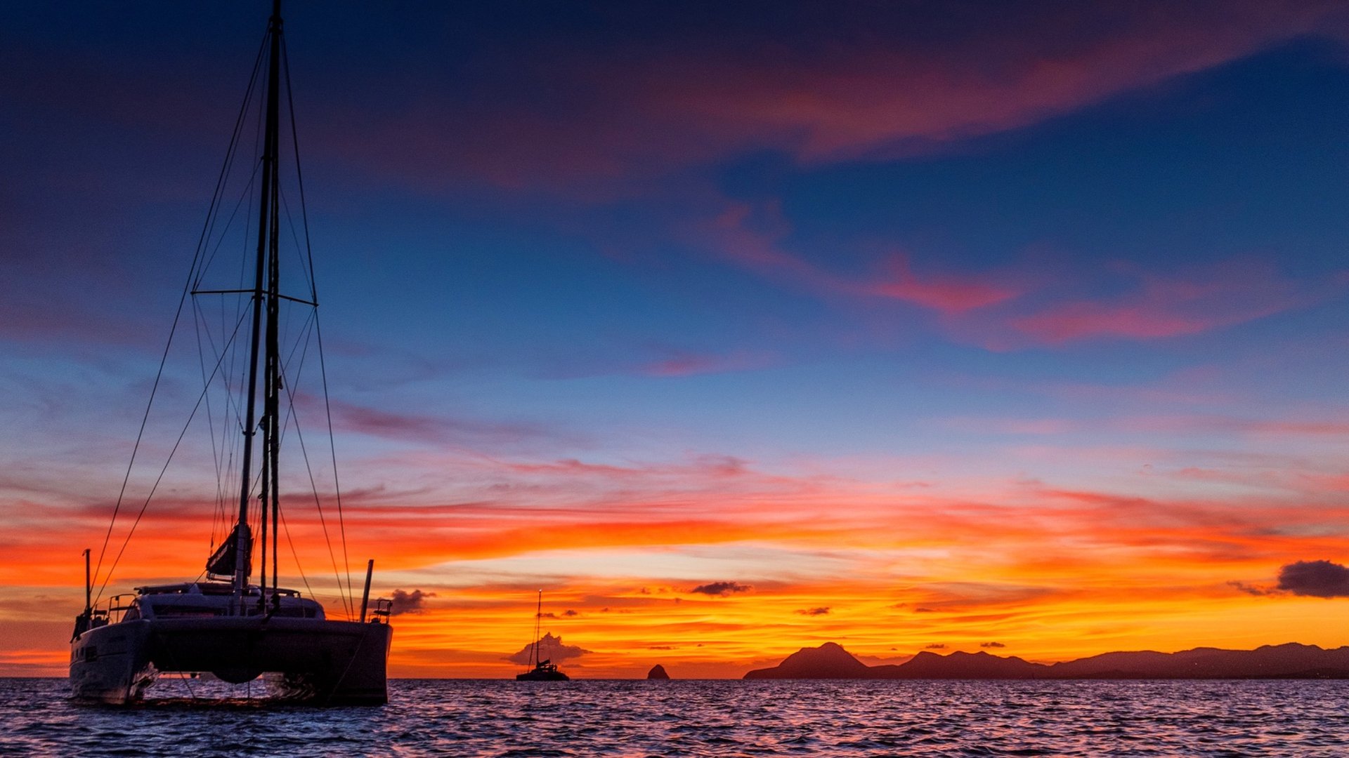Catamaran silhouetted against a dramatic sunset in the British Virgin Islands